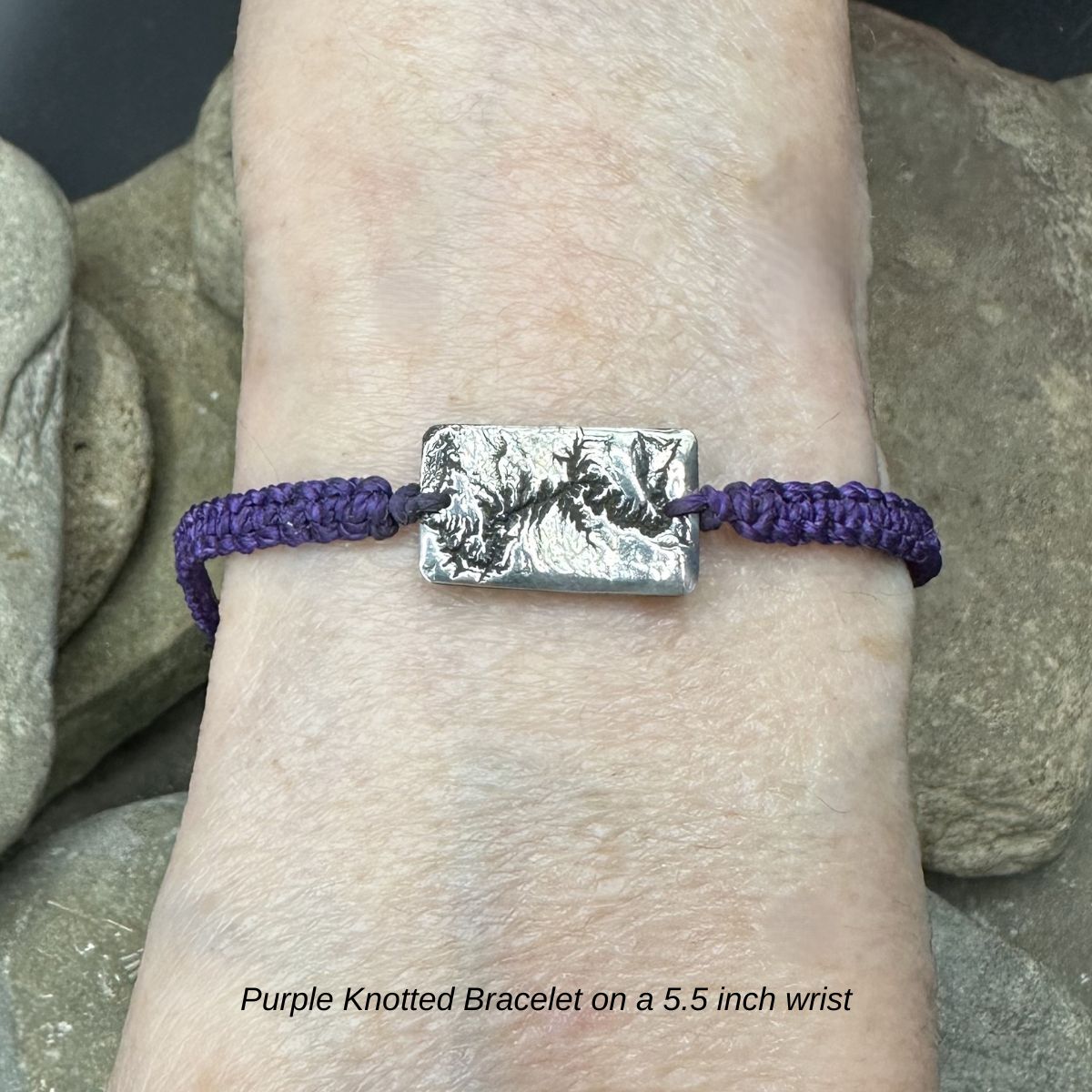 A handcrafted silver bracelet showing the topographic contours of the Grand Canyon – front view of knotted bracelet on 5.5 inch wrist
