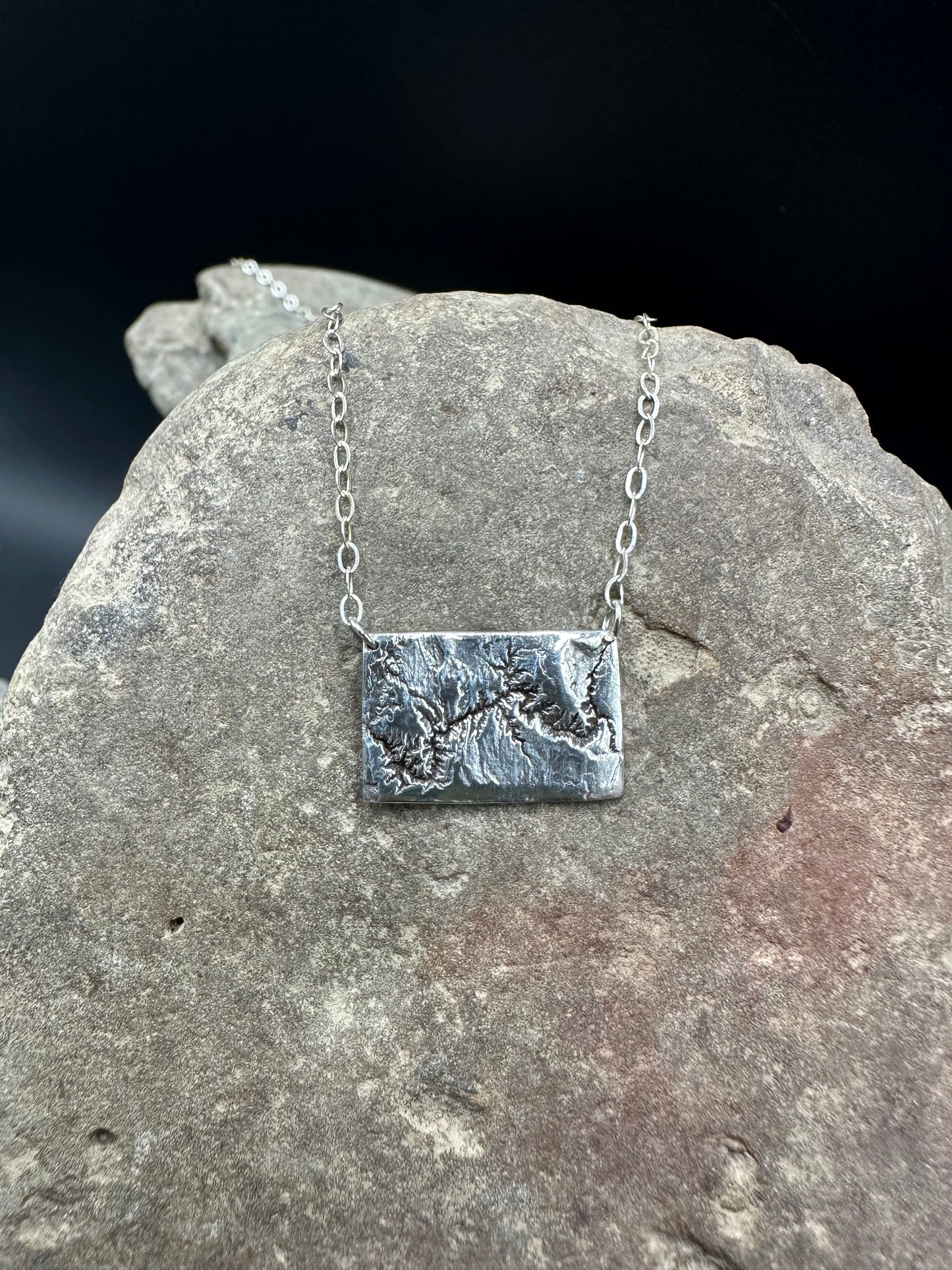 Silver necklace showing the topographic details of the Grand Canyon in Arizona