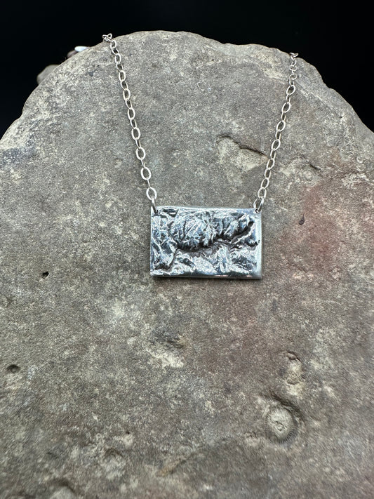 A  handcrafted silver necklace showing the topographic contours of Yosemite – front view
