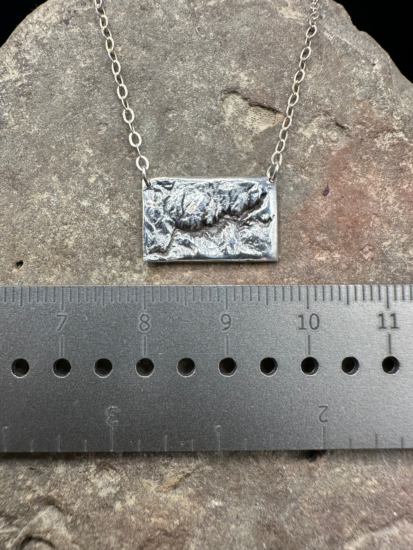 Picture of the 17 mm width of the silver handcrafted necklace showing the topographic details of Yosemite