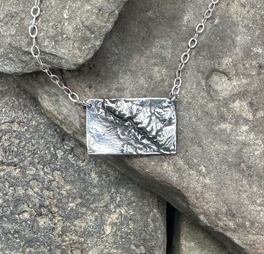 Close up of the Black Canyon of the Gunnison River necklace in silver.